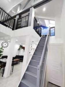 eine weiße Treppe in einem Haus mit einem Wohnzimmer in der Unterkunft Le temps d'une pause 