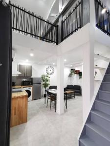 eine Küche und ein Wohnzimmer mit einer Treppe in einem Haus in der Unterkunft Le temps d'une pause 