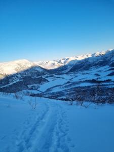 a view of a snow covered field with mountains in the background at Stor leilighet med 4 senger sentralt i Førde in Førde