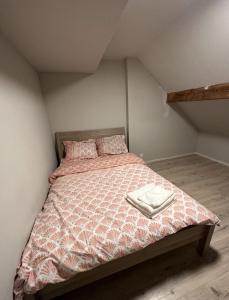 um quarto com uma cama com um edredão e almofadas em 2 bedroom and kitchen em Mons
