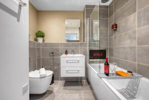 a bathroom with a toilet and a sink and a tub at 1 Bed Stunning City Apt, Southampton Ocean Village, Sleeps 4! By Blue Puffin Stays in Southampton