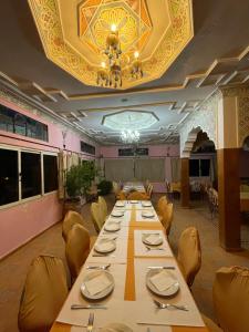 a long dining room with a long table and chairs at Diyar Timnay in Moulay Idriss