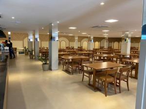 a restaurant with tables and chairs and people in the background at Apartamento completo no resort Water Park in São Pedro