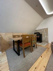 een eetkamer met een tafel en stoelen en een open haard bij Apartman Filip in Kolašin