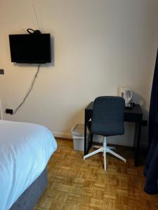 - une chambre avec un bureau, une chaise et une télévision dans l'établissement Dartford Stay, à Kent