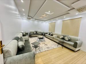 uma grande sala de espera com sofás e um ecrã de projecção em شاليهات بست تايم محايل em Muhayil