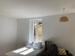 a white room with a bed and a window at Studio 30m2 3 pers centre village in Bessèges