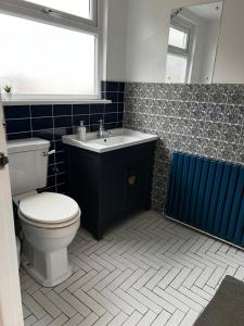 La salle de bains est pourvue de toilettes et d'un lavabo. dans l'établissement Dartford Stay, à Kent