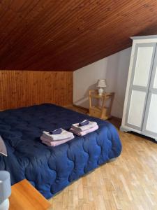 a bedroom with a blue bed with towels on it at Amadeus Pinolo in Gubbio