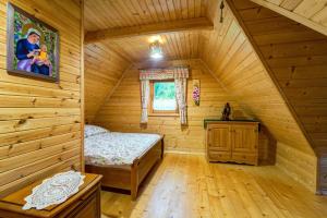 a bedroom with a bed in a wooden cabin at Bacówka Polanki in Obidowa