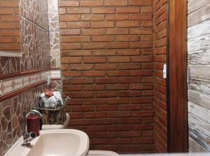 a bathroom with a brick wall and a sink at Hospedagem San Gonzales Two in Sorocaba