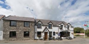 a large white building with black windows at Pass the Keys Modern en-suite room in country PubRestaurant 3 in Llanddona