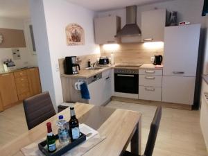 a kitchen with a table with bottles of wine on it at Ferienwohnung Jurk in Bärenstein