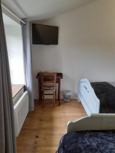 a bedroom with a desk and a bed and a table at Domaine de la Sauzaie in La Pommeraie-sur-Sèvre