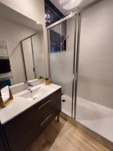 een badkamer met een wastafel en een douche bij Appartement Mimizan Plage accès direct plage surveillée in Mimizan