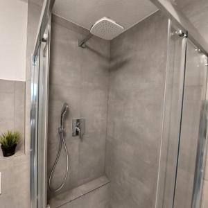 een douche met een douchekop in een badkamer bij DEHOME - Laguna - Stay by Central Station in Koblenz +21 foto's