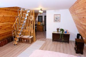 uma sala de estar com uma escada em espiral numa casa em Artarica em Călugăreni