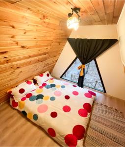 een slaapkamer met een groot bed met polka dot kussens bij Artarica in Călugăreni