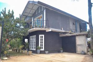 a black house with a balcony on top of it at Heart of the Hill in Nuwara Eliya
