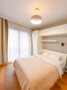 a bedroom with a large white bed and a window at Like Home Apartments in Krakow
