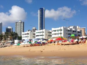 a beach with umbrellas and people on the beach at Apartamento a beira-mar Natal in Natal