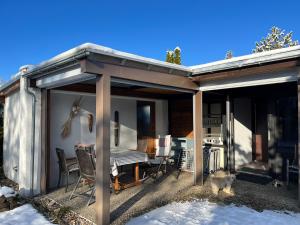 a house with a covered patio with a dog standing outside at Bungalow Nordschwarzwald im Ferienpark Schellbronn in Neuhausen