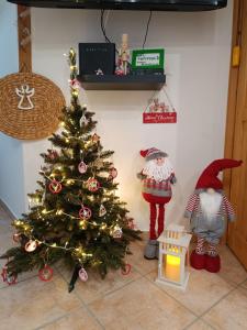 ein Weihnachtsbaum in einem Raum mit zwei Figuren um ihn herum in der Unterkunft Regina Ranch in Igal