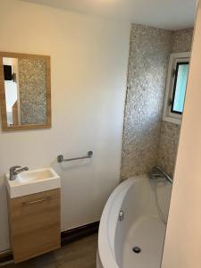 a bathroom with a tub and a sink and a bath tub at Le Nid Castries - Charmant logement complet et équipé Centre Castries proche Montpellier in Castries