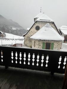 un edificio con techo cubierto de nieve y valla en L'Auberge de L'Ours en Vers L'Eglise