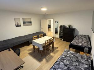 uma sala de estar com uma cama, uma mesa e cadeiras em 5-room apartment (120 sqm) with 2 bathrooms, 2 kitchens, bar area & balcony directly in the city centre em Karlsruhe