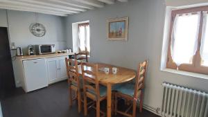 a kitchen with a wooden table and chairs in a room at La Rossignolerie - La familiale Vigneronne in Chouzy-sur-Cisse