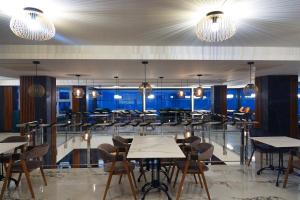 a restaurant with tables and chairs and lights at Dishli Hotel & Spa in Struga