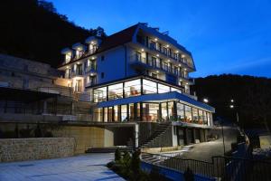 a large blue building with many windows at night at Dishli Hotel & Spa in Struga