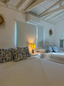 Habitación blanca con 2 camas y lámpara en Casa Grande Hotel Restaurant, en Las Terrenas