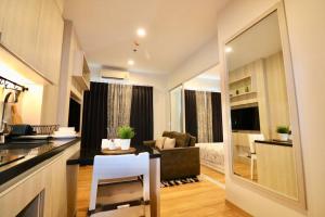 a room with a kitchen and a living room at Condo The Zea Shiracha in Ban Bang Phra