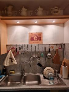 um lavatório de cozinha com utensílios pendurados numa parede em ZELLA HAUS em Obernai