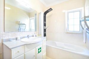 uma casa de banho branca com um lavatório e uma banheira em Apartamento Moderno Albufeira L14 em Albufeira
