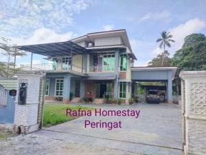 una casa con un cancello davanti di Rafna Homestay a Kota Bharu