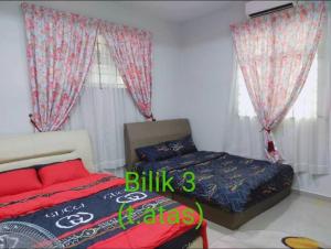 una camera con letto e letto e tende di Rafna Homestay a Kota Bharu
