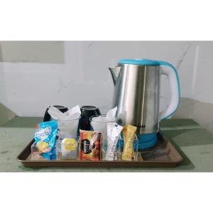 ein Tablett mit einer Kaffeekanne und etwas Essen in der Unterkunft Hotel Daffodils in Rawalpindi