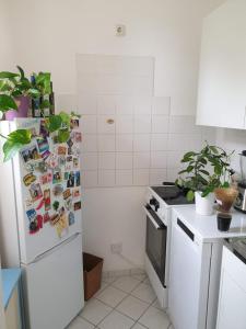 a kitchen with a refrigerator covered in magnets and pictures at Elbe Garden Paradise in Dresden