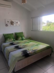 a bedroom with a large bed with a window at Bois patate location in Sainte-Anne