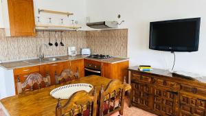 cocina con mesa de madera y TV en la pared en Apartamento La Dehesa, en Uga