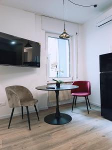 a dining room with a table and two chairs at Apartment Teatro in Bolzano +8 photos