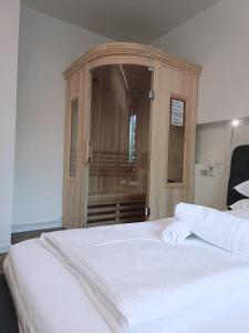 a bedroom with a wooden cabinet with a white bed at Apartment Teatro in Bolzano