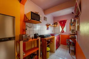 cocina con paredes de color naranja y blanco y microondas en Kaz Zen, en Sainte-Anne