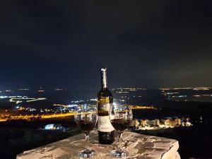 una botella de vino encima de dos copas de vino en צימר בקתה מול הנוף, en Safed