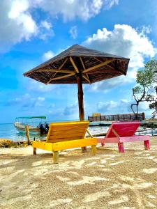 Tres sillas y una sombrilla en una playa en Arena Beach en Tintipan Island