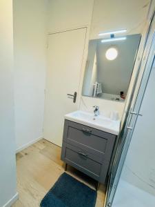 een badkamer met een wastafel en een spiegel bij Coup de cœur~Duplex cocoon vue sur le beffroi -Top Séjour Arras in Arras