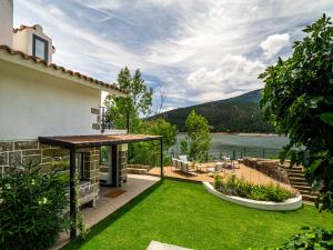 a garden with a view of the water at Casa junto al Pantano de Burguillo in El Tiemblo